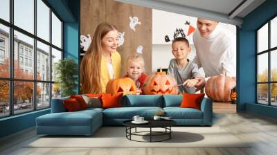 Happy family carving Halloween pumpkins in kitchen Wall mural