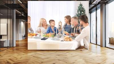 Happy family having Christmas dinner at home Wall mural