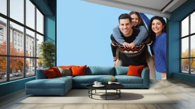 Happy family in warm sweaters on blue background with space for text Wall mural