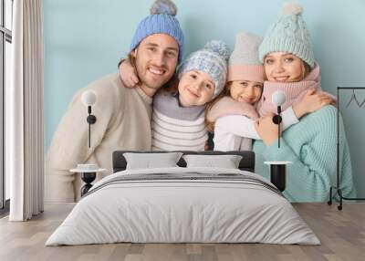 Happy family in winter clothes on color background Wall mural