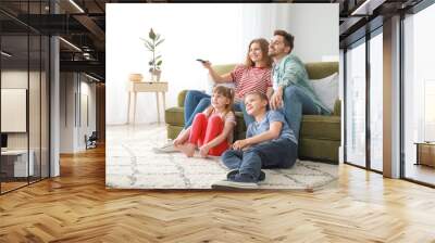 Happy family watching TV at home Wall mural