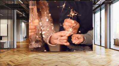 Happy family with sparklers and champagne celebrating Christmas at home, closeup Wall mural