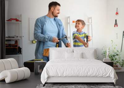 Happy father and his little son with different instruments assembling furniture at home Wall mural