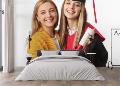 Happy female graduation student with her mother on white background Wall mural