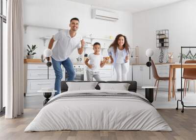 Happy interracial family dancing in kitchen Wall mural