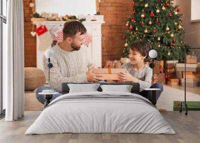 Happy man and his son with Christmas gifts at home Wall mural