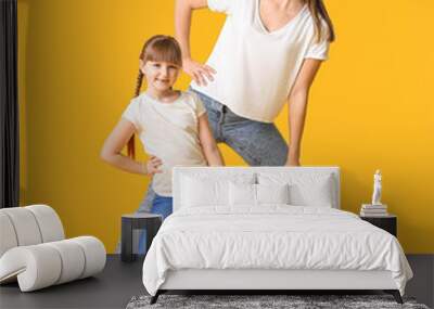 Happy mother and her little daughter dancing against color background Wall mural