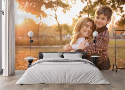 Happy mother and son in autumn park Wall mural