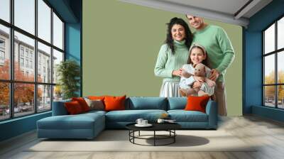 Happy parents with little daughter in warm sweaters on green background Wall mural