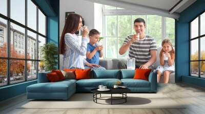 Happy parents with their little children drinking milk at home Wall mural