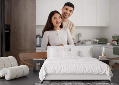 Happy young couple cooking in kitchen Wall mural