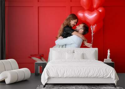 Happy young couple with heart-shaped balloons on color background. Valentine's Day celebration Wall mural