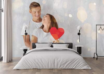 Happy young couple with red heart near grey wall with space for text Wall mural