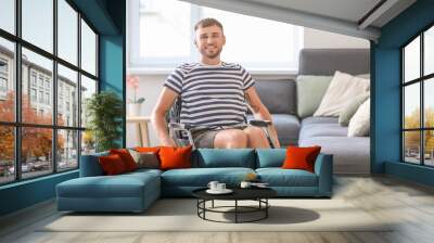 Happy young man in wheelchair at home Wall mural