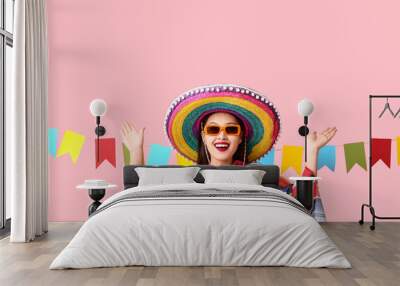 Happy young woman in Mexican sombrero hat and poncho on pink background Wall mural