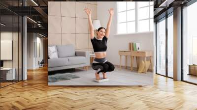 Happy young woman measuring her weight at home Wall mural