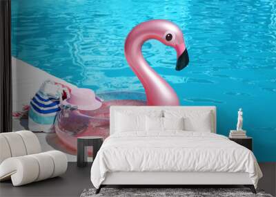 Inflatable ring and beach accessories on edge of swimming pool Wall mural