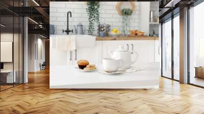 Interior of light kitchen with teapot, cup and snacks on table Wall mural