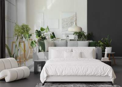 Interior of light living room with comfortable grey sofa and houseplants Wall mural