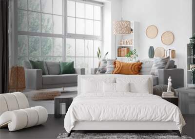 Interior of light living room with grey sofas, coffee table and wicker poufs Wall mural