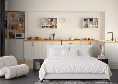 Interior of light modern kitchen with white counters, shelves and food Wall mural