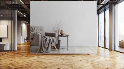 Interior of modern living room with soft armchair, table and tree branches Wall mural