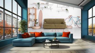 Interior of stylish living room with sofa, bicycle and shelves near white wall Wall mural