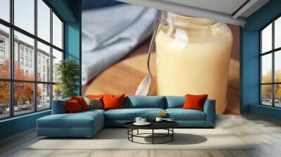 Jar with sweet condensed milk on color background Wall mural