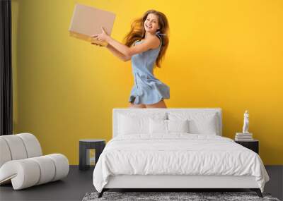 Jumping woman with cardboard box on color background Wall mural