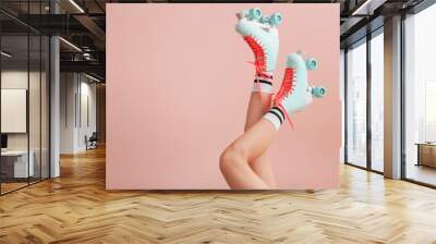 Legs of woman in vintage roller skates on color background Wall mural