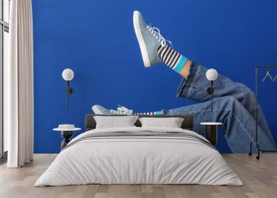 Legs of young woman on color background Wall mural