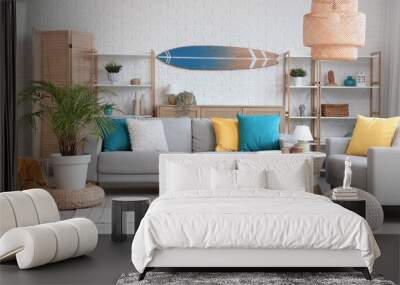 Light interior of living room with cozy sofa, coffee table, lamp and surfboard Wall mural