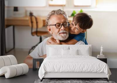 Little boy hugging his grandfather at home Wall mural