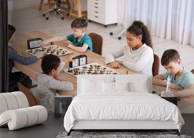 Little children playing chess during tournament in club Wall mural