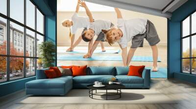 Little children practicing yoga indoors Wall mural