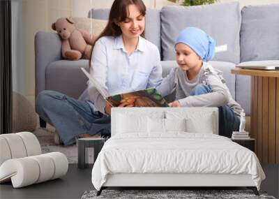 Little girl after chemotherapy with her mother reading story at home. International Childhood Cancer Day Wall mural