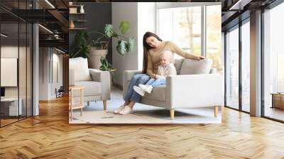 Little girl after chemotherapy with her mother sitting on sofa at home Wall mural