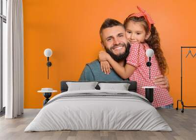 Little girl hugging her father on color background Wall mural