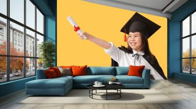 Little girl in graduation hat and with diploma on color background Wall mural