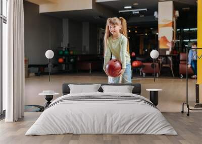 Little girl playing bowling in club Wall mural