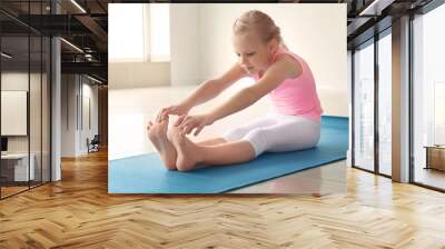 Little girl practicing yoga indoors Wall mural