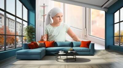 Little girl undergoing course of chemotherapy in clinic Wall mural