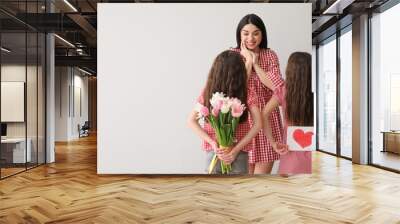 Little girls greeting their mom on light background with space for text. Mother's Day celebration Wall mural