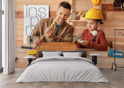 Little son helping his father in carpenter's workshop Wall mural