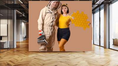 Male beekeeper with smoker and woman in bee costume on brown background Wall mural