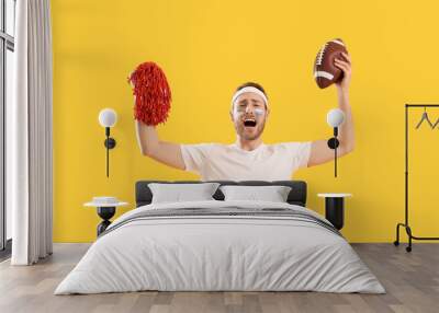 Male cheerleader with rugby ball on color background Wall mural