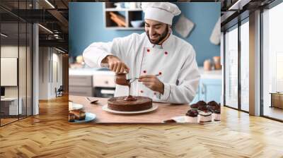 Male confectioner decorating tasty chocolate cake in kitchen Wall mural