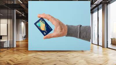 Male hand with credit card on color background Wall mural