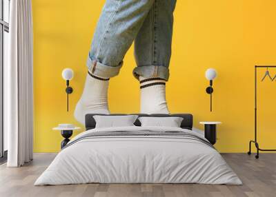 Male legs in socks and jeans on color background Wall mural