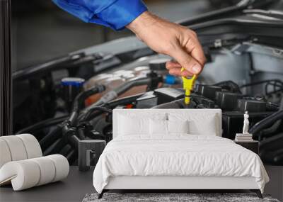 Male mechanic checking level of oil in car engine Wall mural